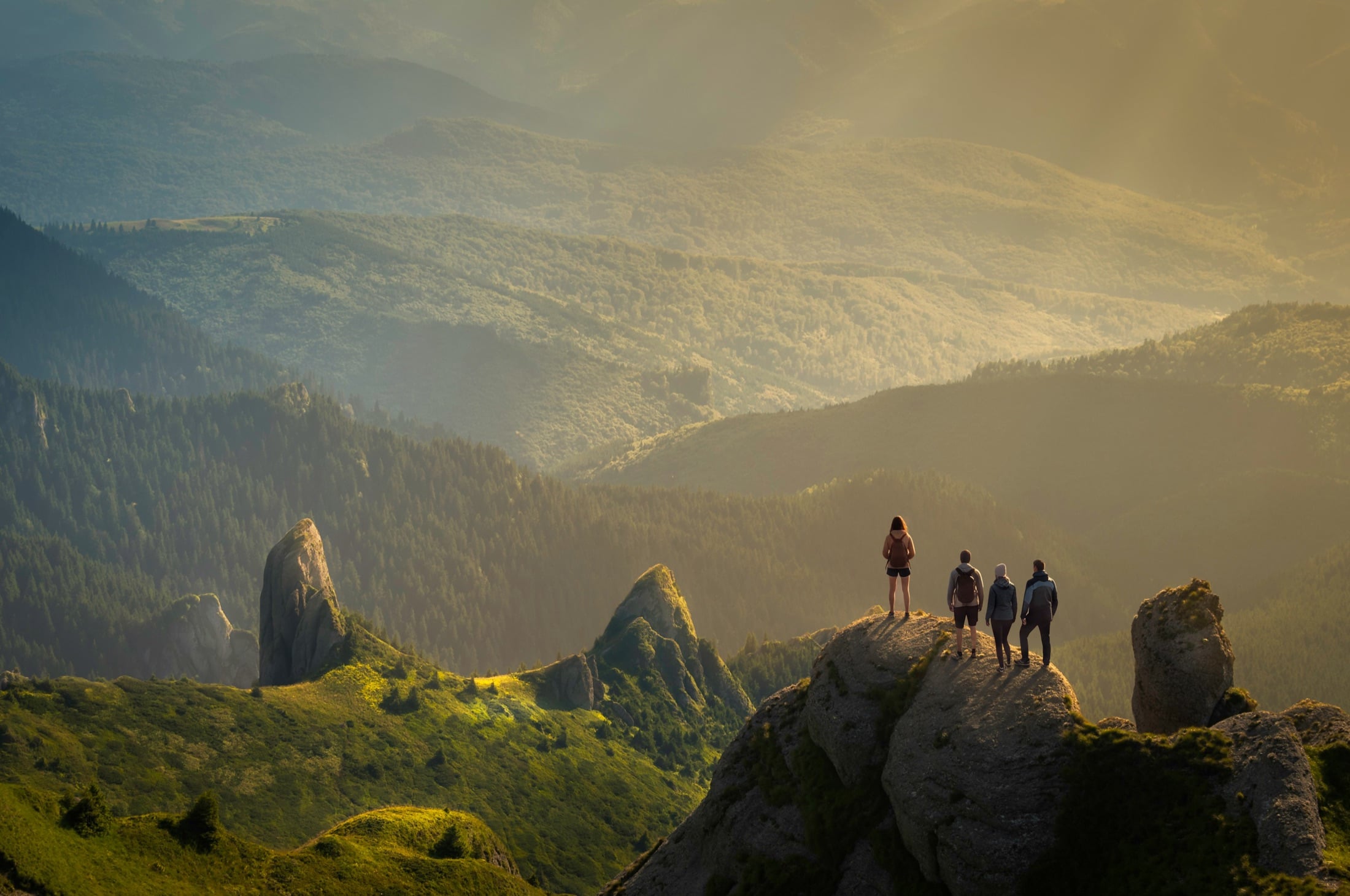 Persone in cima a una montagna al tramonto